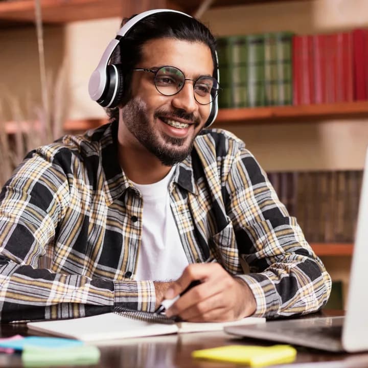 A student wearing headphones during an online Spanish lesson
